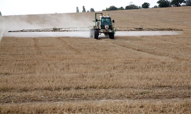 a tractor sprays a field