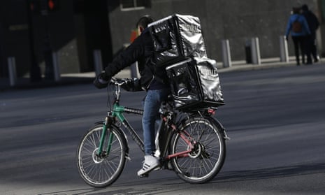 A man making deliveries rides an electronic bike in New York