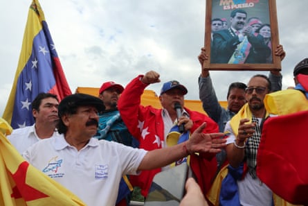People hold flags of Colombia and Venezuela and a portrait of Venezuelan President Nicolás Maduro.