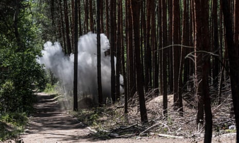 Smoke rises after sappers explode shells during demining process in forested land of Kharkiv Oblast, Ukraine on 17 July 2023.
