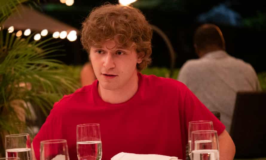 Fred Hechinger as Quinn, sitting at a table with champagne glasses