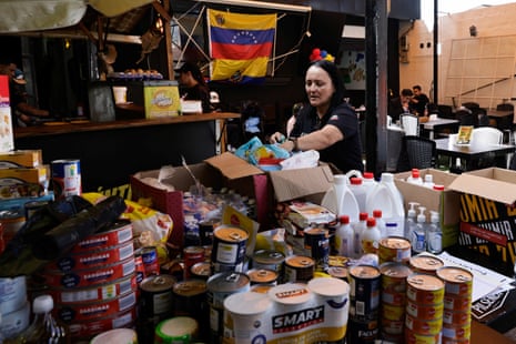 A woman sorting food, medicine and relief supplies at a collection centre.