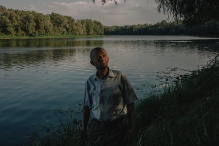 A man stands near the banks of a poisoned river.