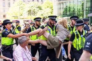Police officers carrying a person away at a protest