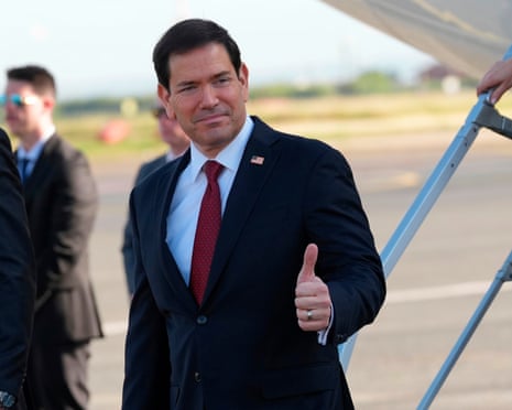 Marco Rubio giving a thumbs-up on a runway.