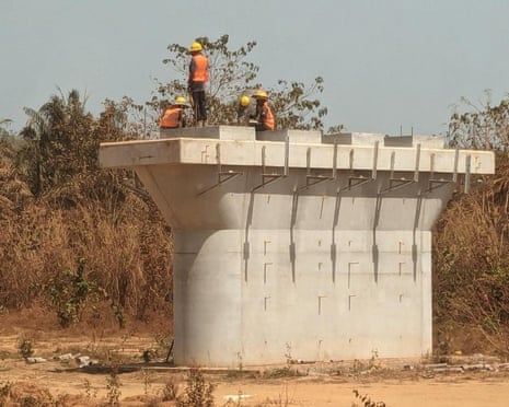 Workers sitting on a rail support column