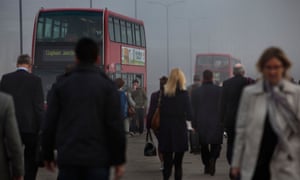 Commuters and busy traffic crossing London Bridge on a smoggy morning