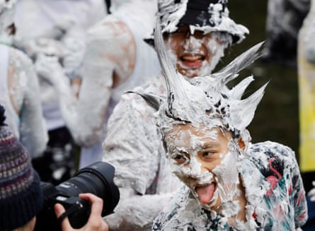 Student covered in foam with punky hair poses with tongue out for another photographer