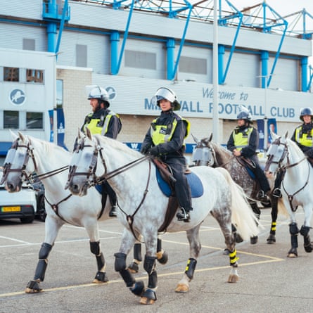 Mounted police move through the car park outside the front of the Den