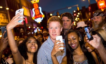 Hicks, looking superficially like Prince Harry, is mobbed by girls taking selfies with him