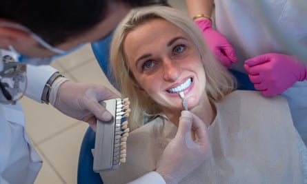 A dentist uses a tooth colour palette to determine the shade of a patient’s teeth.