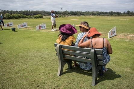 Wealthy locals get ready to play, watched by their wives, at the Mangais golf resort.