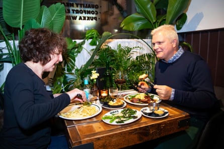 A woman and man facing each other across a restaurant table