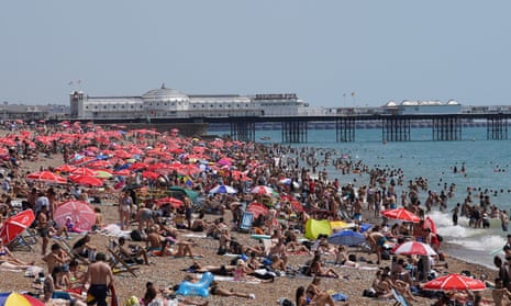 People basking in the sun on a crowded Brighton beach in the UK earlier this year as the Met Office forecasts next year to be one of the world's hottest years. 