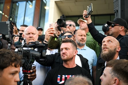 Robinson stands surrounded by demonstrators