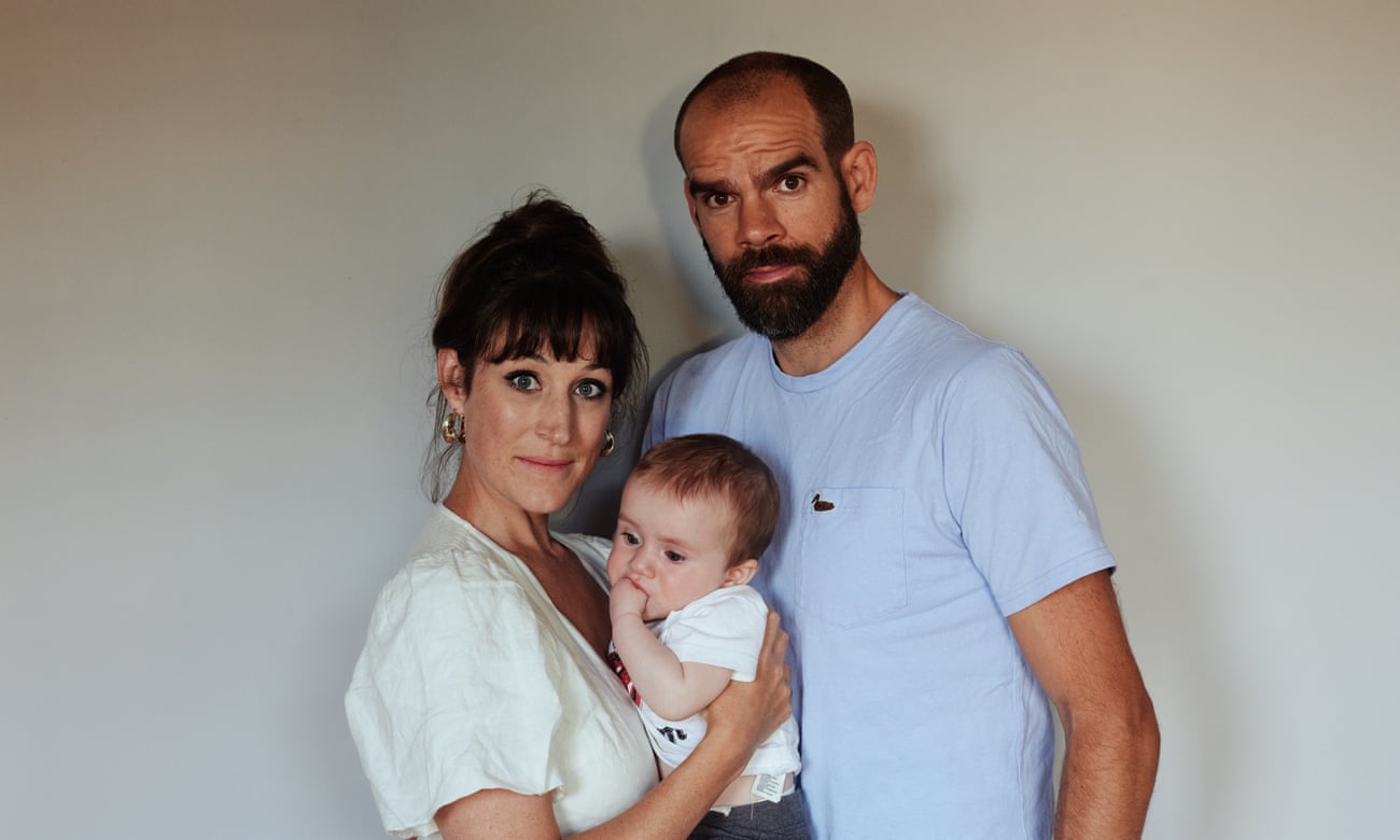 ‘There were voices, muffled as if underwater, and the arms of strangers around my shoulders, steadying me’: Nicola Kelly with her partner and their baby son.