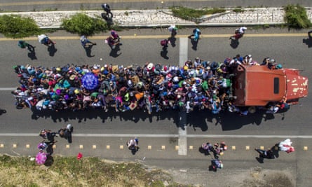 Honduran migrants onboard a truck as they take part in a caravan heading to the US, in the outskirts of Tapachula, on their way to Huixtla on 22 October.