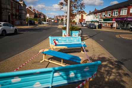 In Layton, Blackpool, colourful seaside-painted benches sit cordoned off on a pavement.