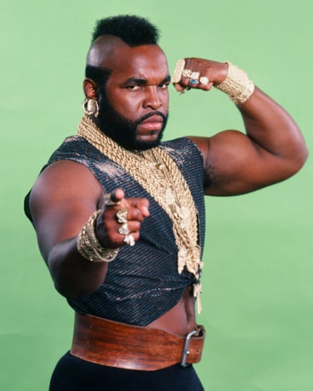 As BA Baracus, wearing gold chains and pointing at the camera
