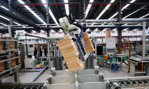 A robotic arm moves wood bricks at a factory in Ganzhou in China