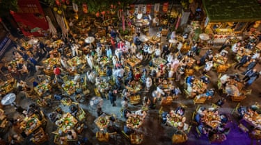 Aerial view of people sitting around tables in a large room at a food festival