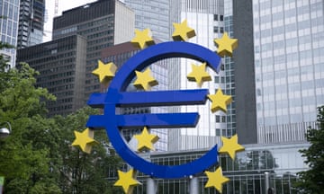 Euro sign in front of skyscrapers.