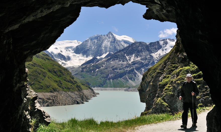 Tourist walking through cave along the Lac des Dix, formed by the Grande Dixence dam in Valais