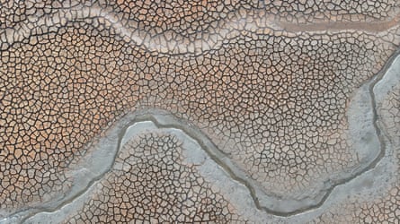 Aerial view of cracked mud on bed of nearly dry reservoir