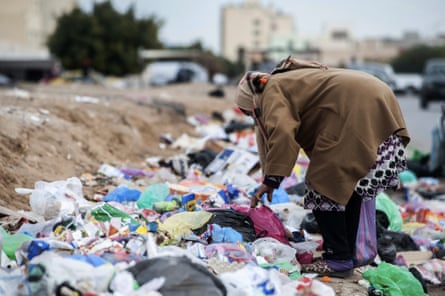 A woman picks through garbage in Kasserine, Tunisia. An estimated 8,000 Tunisians earn a living scavenging plastic for recycling.