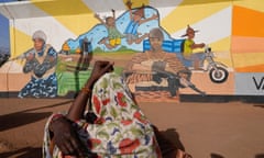 A woman looks at a mural in Ouagadougou