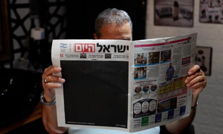 A hairdresser in Jerusalem holds a copy of Israel Today with a blacked-out front page