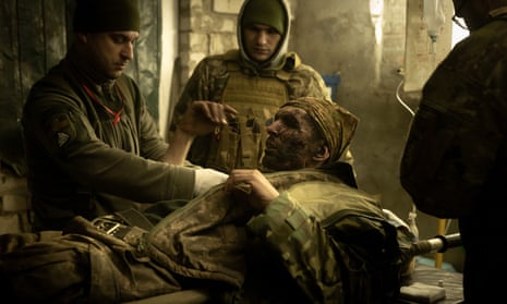 Military medics work on a member of the Ukrainian military suffering from head and leg injuries caused by a mine, in a frontline field hospital on December 04, 2022 outside Bakhmut, Ukraine. Russia continues its campaign to seize Bakhmut, Donetsk region, in what many analysts regard as an offensive with more symbolic value than operational importance for Russia.