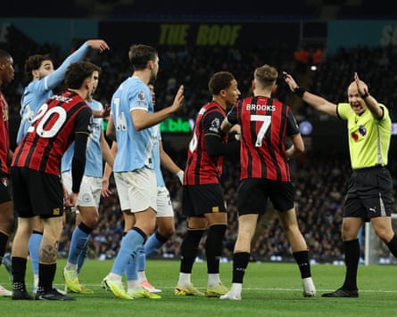 The referee Anthony Taylor waves away player protests during Manchester City’s win against Bournemouth.