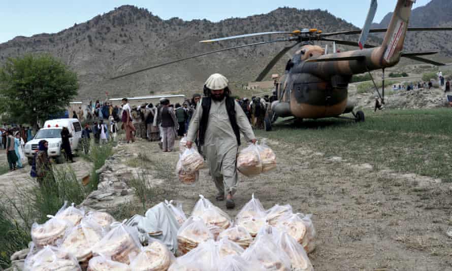 Bread is carried from one of the few helicopters available to the Taliban for aid efforts in Gayan, Afghanistan.