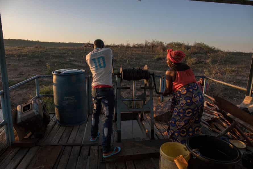 Jimmy, a crew member, and Esnath Munkuli pull up anchor before a night of fishing on the Zambezi River