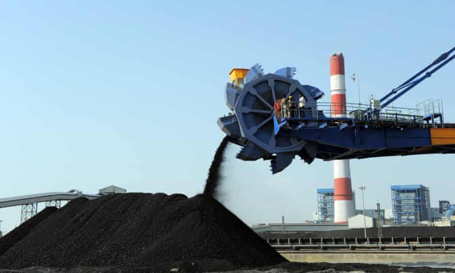 Indian workers use heavy machinery to sift through coal at the Adani Power company thermal power plant at Mundra 400km from Ahmedabad.