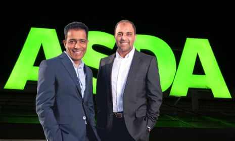 Mohsin and Zuber Issa, owners of the UK supermarket chain Asda, in front of a company logo