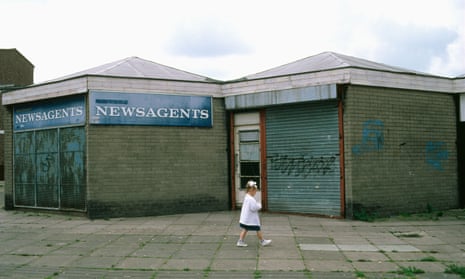 A small girl walks past a closed-down shop on an estate in Skelmersdale, Lancashire