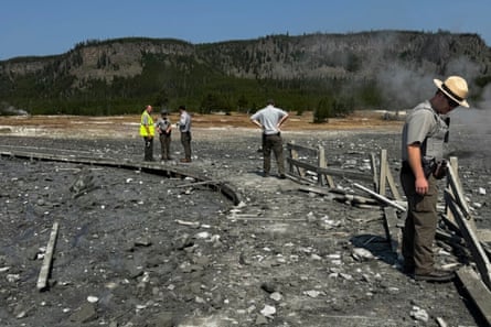 In this photo released by the National Park Service, park staff assess the damage to Biscuit Basin boardwalks after a hydrothermal explosion.
