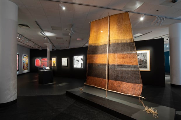 A 2.8m-high hand-woven pandanus sail hangs in an open plan gallery space