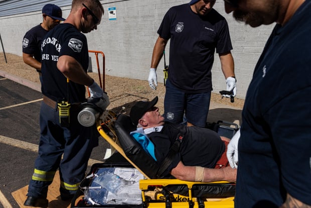 Paramedics attend to a man in a stretcher outside