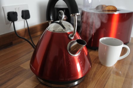 Kettle boiling with steam and toaster cooking toast behind in kitchen