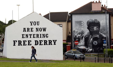 The mural on the right, depicting a boy clutching a petrol bomb was painted by Tom Kelly in the 1990s as one of a series of 12 murals telling the story of Bloody Sunday.