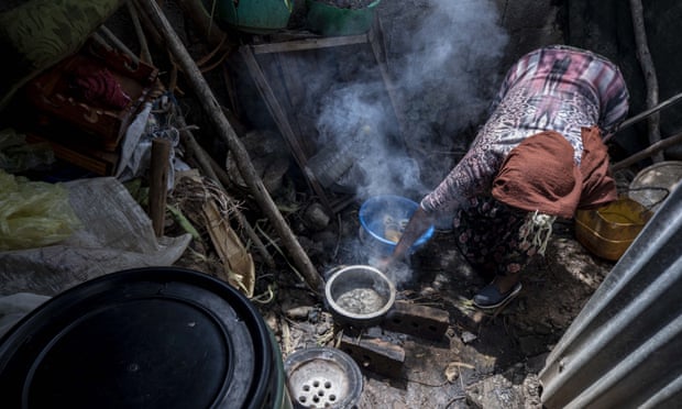 A woman in Ethiopia who lost her job because of the coronavirus pandemic prepares food for her family in a small tent.