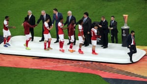 Arsenal manager Unai Emery looks dejected as he walks past the Europa League trophy.