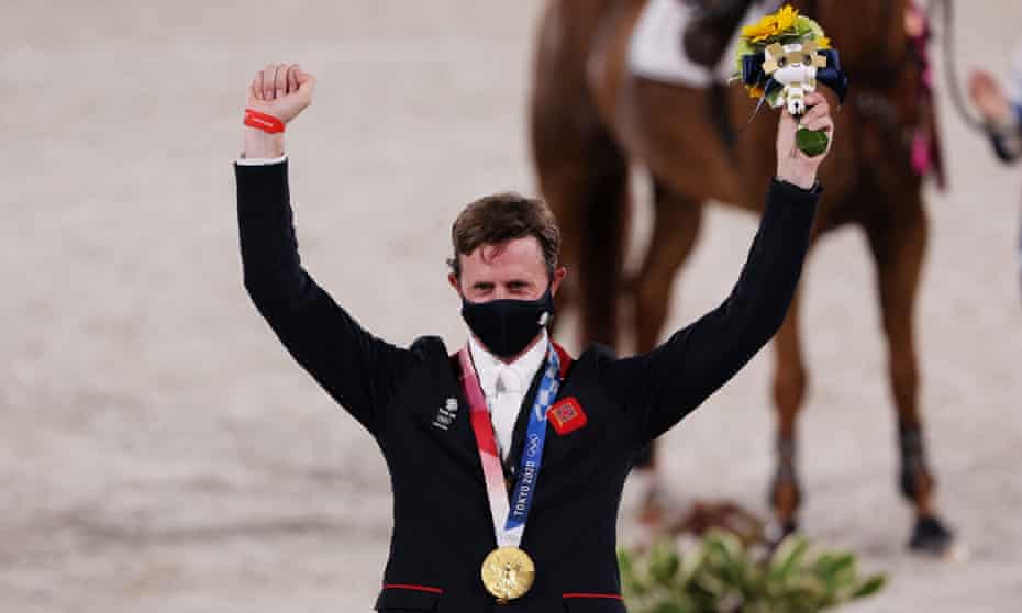 Great Britain’s Ben Maher celebrates on the podium after receiving his gold medal.