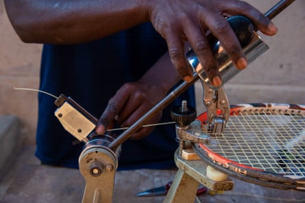 Tennis coach Charles Ssenyange restrings a racket at home in Kasangati