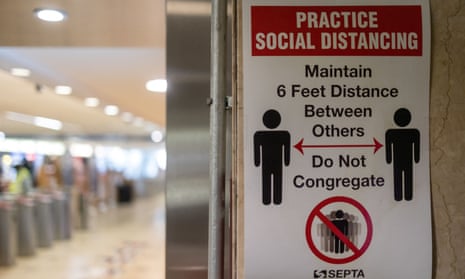 A sign advising social distancing is posted on a wall in a transit station in Philadelphia.