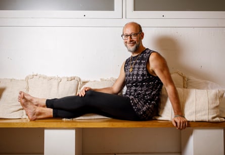 Cruickshank sitting on a bench against some cushions with his legs out in front of him