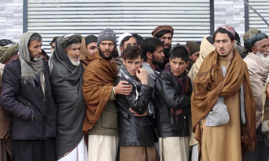 Afghans queue to receive food rations organised by the World Food Program in Pul-e-Alam, eastern Afghanistan